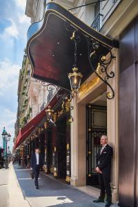 a man in a suit standing in front of a building at Hotel Westminster in Paris