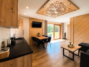 a kitchen and living room with a table and chairs at Jagodowe Domki in Ciche
