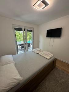 a bedroom with a bed with a flat screen tv at Villa Sofia in Bihać