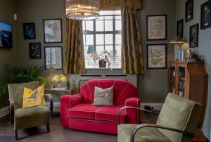 a living room with a red chair and a window at Leeds Castle Lakeside Lodges in Broomfield