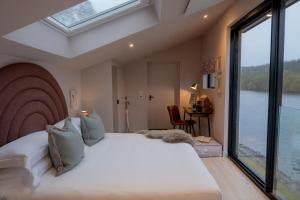 a bedroom with a large bed and a large window at Leeds Castle Lakeside Lodges in Broomfield +16 photos