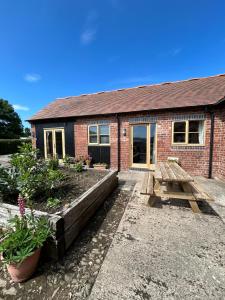 ein Backsteinhaus mit Garten davor in der Unterkunft Rural cottage in Shropshire Hills in Leebotwood