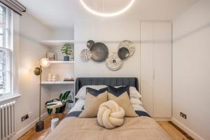 a bedroom with a bed in a room with white walls at Pottter's Perch - Covent Garden - By Frankie Says in London