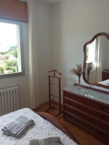 a bedroom with a dresser and a mirror on a bed at Acogedora casita de campo in Bóveda