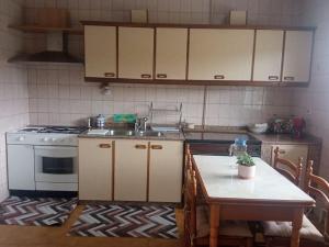 a kitchen with a table and a sink and a stove at Acogedora casita de campo in Bóveda