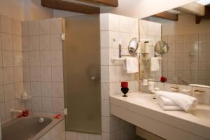 a bathroom with a tub and a sink and a mirror at Hotel Mohren in Ochsenhausen