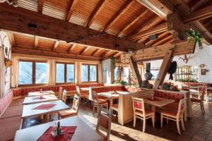 a restaurant with wooden ceilings and tables and chairs at Sonnalm Lechtal in Bach