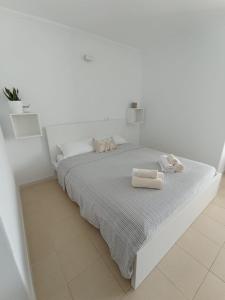 a white bedroom with a bed with two towels on it at Zen Apartment Tenerife in San Miguel de Abona