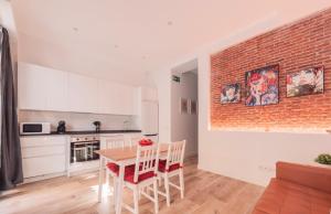 a kitchen with a table and a brick wall at Apartamento El Rastro - Centro de Madrid in Madrid