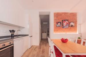 a kitchen with a wooden table and a brick wall at Apartamento El Rastro - Centro de Madrid in Madrid +16 photos