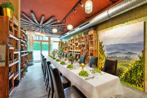 a long dining room with a long table and chairs at Hotel Müller Café & Wein - Mondholzhotel in Veitshöchheim