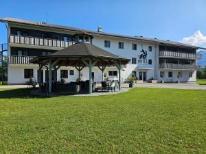 a building with a gazebo in front of it at Hotel Fuchs & Hase SELF CHECK IN in Rosegg