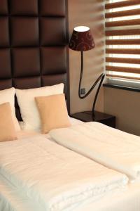 a bedroom with a bed with a black headboard and a lamp at Hotel Rosenmeer in Mönchengladbach