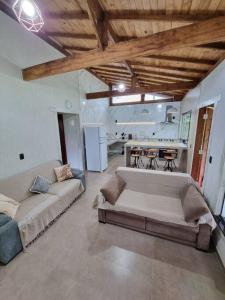 a living room with two couches and a kitchen at Chácara Brisa do Rio 2 in Núcleo Colonial