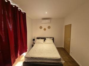 1 dormitorio con 1 cama grande y cortinas rojas en #Panoramique#T3#Balcon#Thiers#, en Thiers