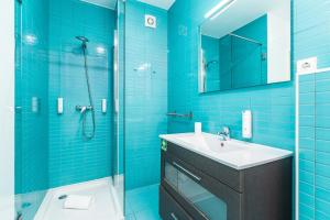 a blue bathroom with a sink and a shower at Dream On - Clérigos Lofts in Porto