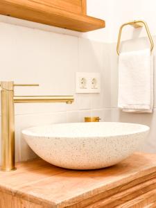uma casa de banho com um grande lavatório em pedra num balcão de madeira em A Casa de Canosiña by ALÔGA em Fisterra