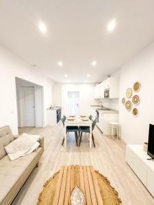 uma sala de estar branca com uma mesa e um sofá em A Casa de Canosiña by ALÔGA em Fisterra