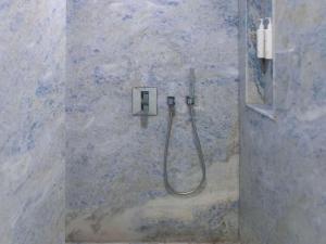 a shower with a hose attached to a stone wall at Swissôtel Resort Bodrum Beach in Turgutreis