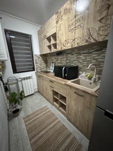 a kitchen with a sink and a microwave at Oly Apartment in Năvodari