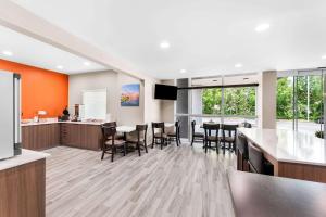 cocina abierta y comedor con mesas y sillas en Sleep Inn & Suites Pigeon Forge Downtown, en Pigeon Forge