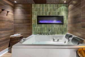 默特尔比奇Hilton Grand Vacations Club Anderson Ocean Myrtle Beach的一间带浴缸的浴室,墙上配有电视