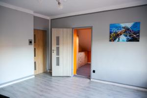 an empty room with a door and a painting on the wall at Apartament Górna in Gołdap +2 photos