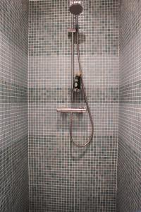 a shower in a bathroom with a tiled wall at Beautiful home with private pool in Vélez de Benaudalla