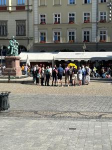 a group of people standing in front of a building at Rynek pod Fredrą in Wrocław