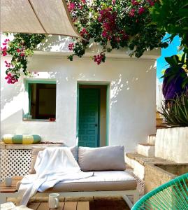 a couch sitting in front of a building with flowers at Beautiful home with private pool in Vélez de Benaudalla