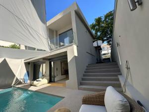 una casa con piscina di fronte a una casa di ILION Villa ad Atene