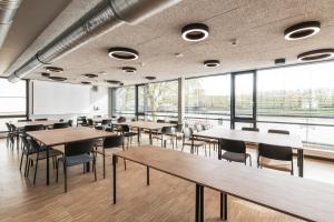 a room with tables and chairs and windows at Jugendherberge Bremen in Bremen +10 photos