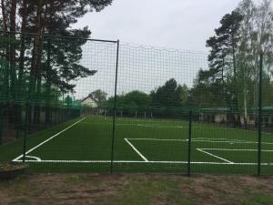 a tennis court with a net on a tennis court at Owk Korona in Mikoszewo +22 photos