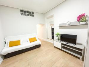 a living room with a couch and a television at Trinidad del Mar Turistea in Castellón de la Plana