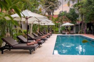 a row of chairs and umbrellas next to a swimming pool at The Oasis Harbor in Siem Reap