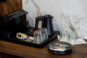 a tray with a coffee maker and glasses on a table at Sleep&Fly Okęcie Warsaw Airport in Warsaw