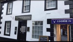 a white building with signs on the side of it at Black Bull with Rooms lower in Cumbernauld