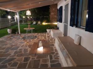 a patio with a bench and a table in a yard at Vasiliki in Kavála