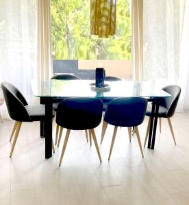 mesa de comedor con sillas azules y mesa de cristal en LAUSANNE PULLY sunny apartment on lakeside street and direct bus to Lausanne train station, en Pully 44 fotos más