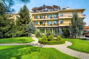 an apartment building with a garden in front of it at Парк-Хотел Клементина in Trud