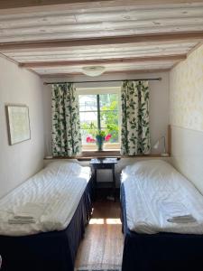 two beds in a room with a window at Adagio på Österlen in Kivik