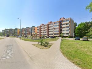 an empty street in front of a large building at Sunny flat 250m from the beach in Liepāja