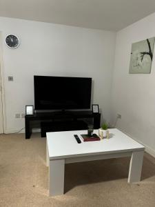 ein Wohnzimmer mit einem weißen Couchtisch und einem TV in der Unterkunft Winstanley Stay in Chesterton