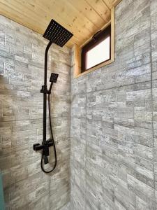 a shower in a bathroom with a stone wall at Cottage GORDA Kazbegi in Akhalts'ikhe +31 photos