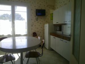 a kitchen with a table and chairs and a window at le pavillon a la campagne in La Perche +5 photos