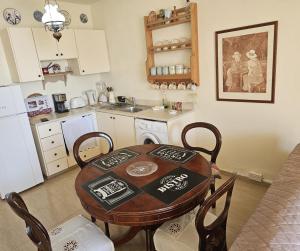 a kitchen with a wooden table and chairs in a room at Summer Bliss Apartment Peyia in Peyia