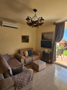 a living room with a couch and a tv at Summer Bliss Apartment Peyia in Peyia
