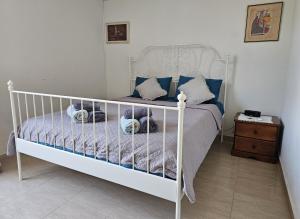 a bedroom with a white bed with blue pillows at Summer Bliss Apartment Peyia in Peyia +16 photos