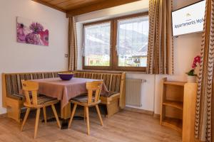Un comedor con mesa y sillas y una ventana. en Appartements Hofer, en San Giacomo