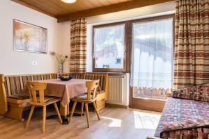 Un comedor con mesa y sillas y una ventana. en Appartements Hofer, en San Giacomo